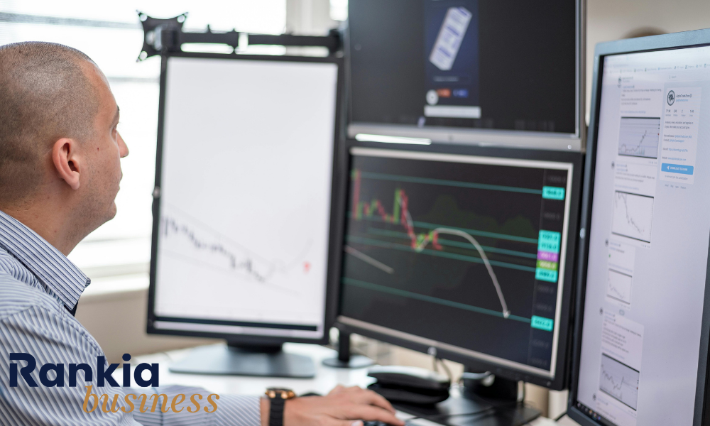 Persona analizando informes financieros en pantalla, representando la gestión presupuestaria y el control de gastos empresariales.