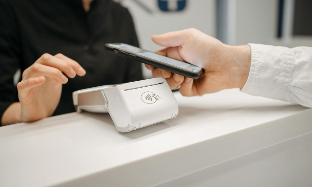 Persona pagando con el móvil en un datáfono libre o TPV sin banco mediante tecnología contactless.