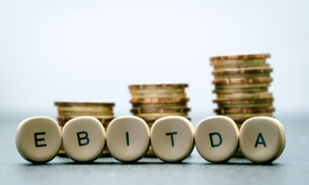 Montones de monedas formando la palabra EBITDA, que representa la rentabilidad operativa de una empresa.