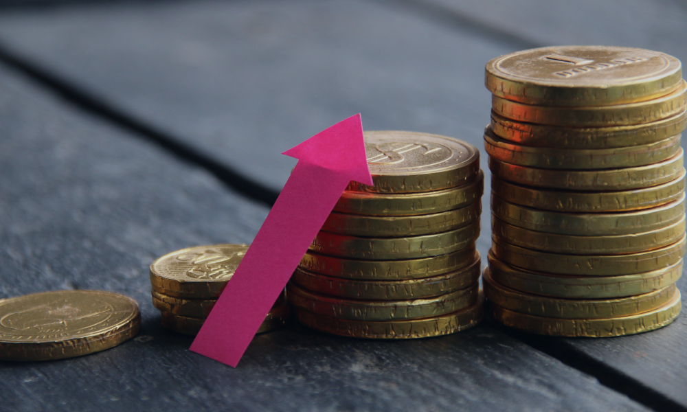 Montones de monedas con una flecha ascendente que simboliza el crecimiento del EBITDA y la mejora del rendimiento financiero.
