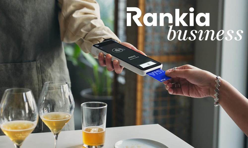 Persona cobrando con un TPV de Square en un bar moderno, mostrando la pantalla táctil y el lector de tarjetas.