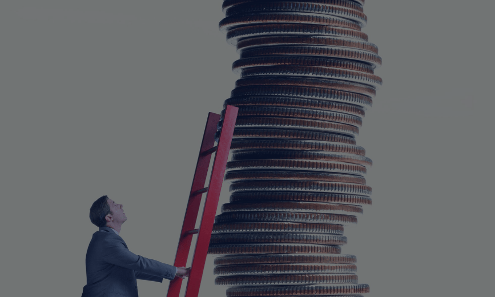 Empresario con una escalera apoyada en una alta torre de monedas que representa la financiación para grandes proyectos.